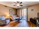 Bright living room featuring wood floors, ceiling fan, and access to a private outdoor balcony at 1651 W Canal Cir # 613, Littleton, CO 80120