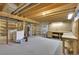Unfinished basement with exposed wood beams, laundry area and workshop space ready for customization at 8871 E Amherst Dr # B, Denver, CO 80231