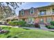 Inviting townhouse with brick exterior, manicured landscaping, and cozy outdoor seating area at 8871 E Amherst Dr # B, Denver, CO 80231