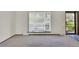 Bright and open living room featuring large window, door, and carpeted area at 8871 E Amherst Dr # B, Denver, CO 80231