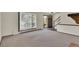 Bright living room featuring large window, door, and staircase adjacent to a carpeted area at 8871 E Amherst Dr # B, Denver, CO 80231