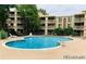Outdoor community pool with lounge chairs and mature trees surrounding the area at 1302 S Parker Rd # 127, Denver, CO 80231