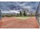 Outdoor tennis court featuring a red surface, green playing area, and surrounding fence at 1302 S Parker Rd # 127, Denver, CO 80231