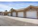 Row of detached garages with white doors and brick accents, providing convenient parking at 9227 Rolling Way # 201, Parker, CO 80134