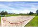 Outdoor sand volleyball court with red boundary line, surrounded by green grass at 9227 Rolling Way # 201, Parker, CO 80134