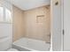 Bathroom with white tub, neutral tile surround, and modern fixtures at 469 S Perry St, Denver, CO 80219