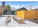 View of the house with a detached garage and a newly installed wooden fence at 469 S Perry St, Denver, CO 80219