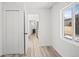 Hallway with updated flooring, white walls and an open doorway to the kitchen at 469 S Perry St, Denver, CO 80219