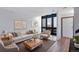 Staged living room featuring hardwood floors, a large window, and a front door at 10390 Tumbleweed Dr # 7, Thornton, CO 80229