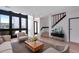 Staged living room featuring hardwood floors, a large window, and a stairway to the second level at 10390 Tumbleweed Dr # 7, Thornton, CO 80229