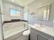 Bathroom featuring a shower and tub combo, gray vanity, and decorative tile accents at 2533 E 90Th Pl, Thornton, CO 80229