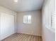 Bright bedroom featuring wood-look floors, a window with natural light, and a closet with sliding doors at 2533 E 90Th Pl, Thornton, CO 80229