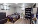 Bedroom showcasing wood-look floors, dual windows, and ample space with a large bookcase at 2533 E 90Th Pl, Thornton, CO 80229