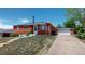 Charming red brick home with well-maintained lawn and detached garage on a sunny day at 2533 E 90Th Pl, Thornton, CO 80229