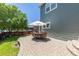 Back patio features outdoor seating area under an umbrella and well maintained lawn at 2488 Lake Vista Dr, Broomfield, CO 80023