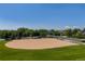 A ground-level shot of a baseball field with a grassy outfield and backstop in a suburban park setting at 2488 Lake Vista Dr, Broomfield, CO 80023