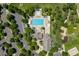 A top-down view of a community pool with lounge chairs, a playground, and a parking lot surrounded by trees at 2488 Lake Vista Dr, Broomfield, CO 80023