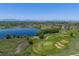 Aerial view of a golf course near a lake, featuring mountains in the background on a clear day at 2488 Lake Vista Dr, Broomfield, CO 80023