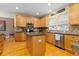 Bright kitchen with stainless steel appliances, center island, granite countertops, and wood cabinets at 2488 Lake Vista Dr, Broomfield, CO 80023