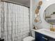 A modern bathroom features navy blue vanity, decorative mirror, and elegant shower curtain at 5342 S Halifax Cir, Centennial, CO 80015