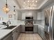 Modern kitchen with stainless steel appliances, gray cabinetry, subway tile backsplash, and pendant lights at 5342 S Halifax Cir, Centennial, CO 80015