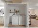 Functional laundry closet with washer, dryer, storage shelf, and cleaning supplies, offering practicality and organization at 5342 S Halifax Cir, Centennial, CO 80015