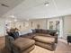 Cozy living room with a large sectional couch, textured rug, and access to the outside through glass panel doors at 5342 S Halifax Cir, Centennial, CO 80015