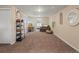 Expansive living space with neutral walls, carpet flooring, a desk, and an adjacent seating area with a comfortable chair at 5342 S Halifax Cir, Centennial, CO 80015