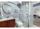 Well-lit bathroom featuring a marble shower, wooden vanity, and modern fixtures at 10478 Ogden St, Northglenn, CO 80233