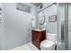 Cozy bathroom with a cherry vanity, oval mirror, and classic fixtures at 10478 Ogden St, Northglenn, CO 80233