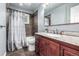 Charming bathroom featuring a shower with patterned curtain, granite vanity, and wooden cabinets at 10478 Ogden St, Northglenn, CO 80233