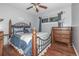 Comfortable bedroom with a decorative metal bed frame, ceiling fan, and hardwood floors at 10478 Ogden St, Northglenn, CO 80233