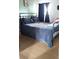 Bedroom featuring a black metal frame bed with hardwood flooring, dark curtains, and pale green walls at 1242 S Seneca Way, Denver, CO 80223