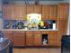 Traditional kitchen with oak cabinets, tile backsplash, light countertops, and a gas range at 1242 S Seneca Way, Denver, CO 80223
