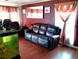 Cozy living room with a plush leather sofa, hardwood floors, an aquarium, and decorative curtains at 1242 S Seneca Way, Denver, CO 80223