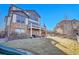A two-story home featuring a stone facade and a deck with outdoor seating and a grill at 8726 Gardenia Cir, Arvada, CO 80005