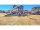 Expansive backyard featuring a playset and mature trees, with a view of the home's exterior at 8726 Gardenia Cir, Arvada, CO 80005