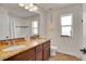 Well-lit bathroom featuring a double vanity and a shower-tub combo at 8726 Gardenia Cir, Arvada, CO 80005