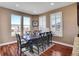 Elegant dining room features wood floors, natural light, and a large table with seating for eight at 8726 Gardenia Cir, Arvada, CO 80005