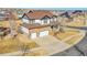 Two-story home with a well-manicured lawn and a three-car garage, showcasing classic curb appeal at 8726 Gardenia Cir, Arvada, CO 80005