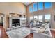 Living room featuring a stone fireplace, large windows, and comfortable sectional sofa at 8726 Gardenia Cir, Arvada, CO 80005