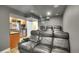 Modern theater room with comfortable leather reclining seats, a projector, and a wet bar for convenient entertaining at 8726 Gardenia Cir, Arvada, CO 80005