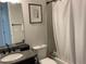 A cozy bathroom with a granite countertop, decorative shower curtain and framed artwork at 2617 Channel Dr, Highlands Ranch, CO 80129