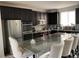 Modern kitchen with stainless steel appliances, a granite island, and dark cabinets at 2617 Channel Dr, Highlands Ranch, CO 80129