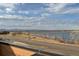 Scenic lake view featuring open sky and distant mountains from a modern balcony with brown wooden siding and metal railing at 2617 Channel Dr, Highlands Ranch, CO 80129