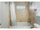Bathroom featuring a shower-tub combo and neutral tile at 557 S Clarkson St, Denver, CO 80209