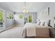 Bright bedroom featuring a modern chandelier, neutral decor, and large windows for natural light at 557 S Clarkson St, Denver, CO 80209