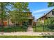 Charming two-story home featuring a stone facade, black iron fence, and a cozy front porch with a blue bench at 557 S Clarkson St, Denver, CO 80209
