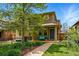 Charming stone-clad two-story home with landscaped front yard and inviting blue bench on the front porch at 557 S Clarkson St, Denver, CO 80209