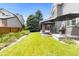 Landscaped backyard with a covered patio, lush green lawn, and privacy fence at 6772 Tiger Tooth, Littleton, CO 80124